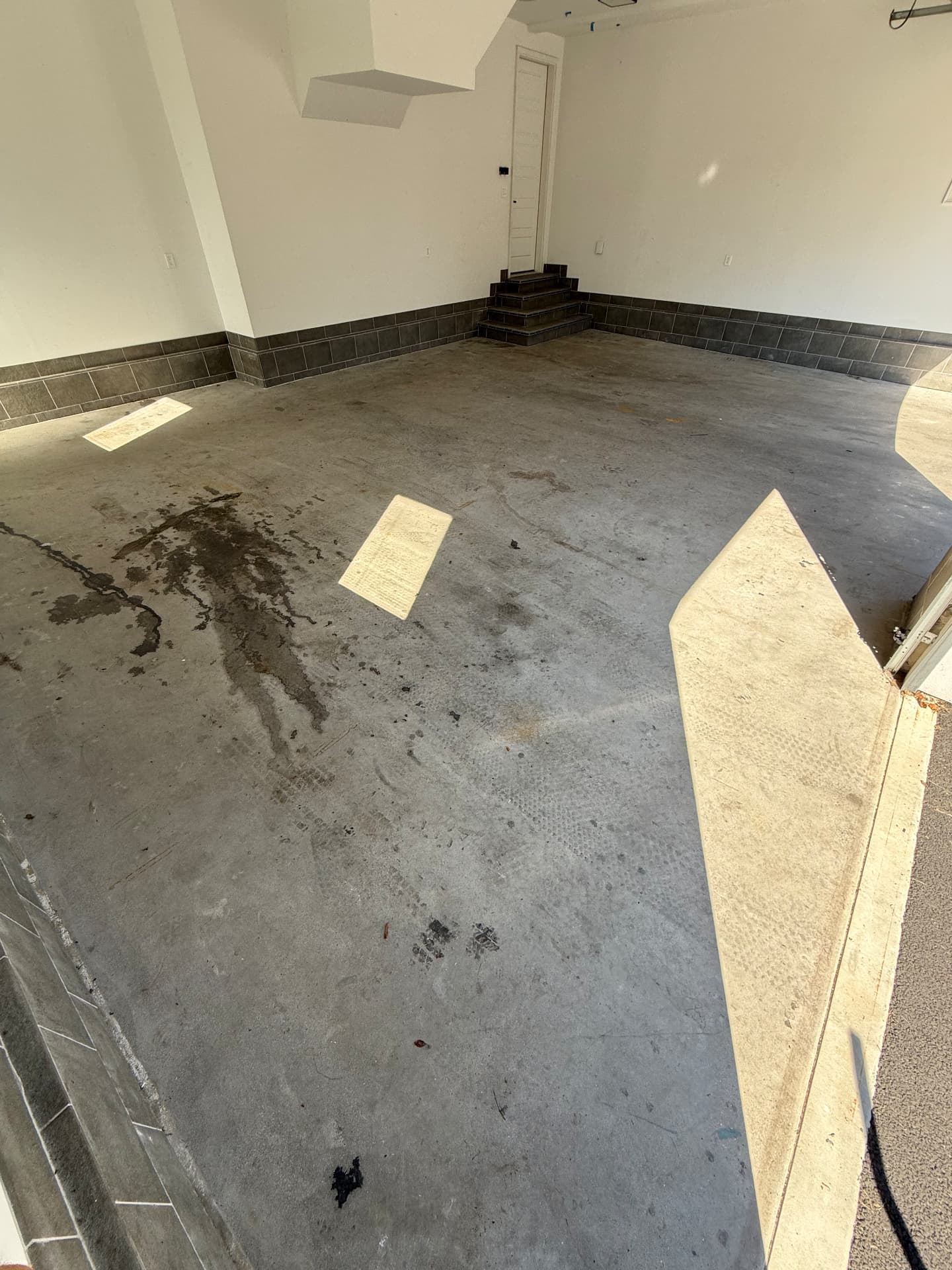 Stained bare concrete garage floor before coating in West Springfield, Massachusetts